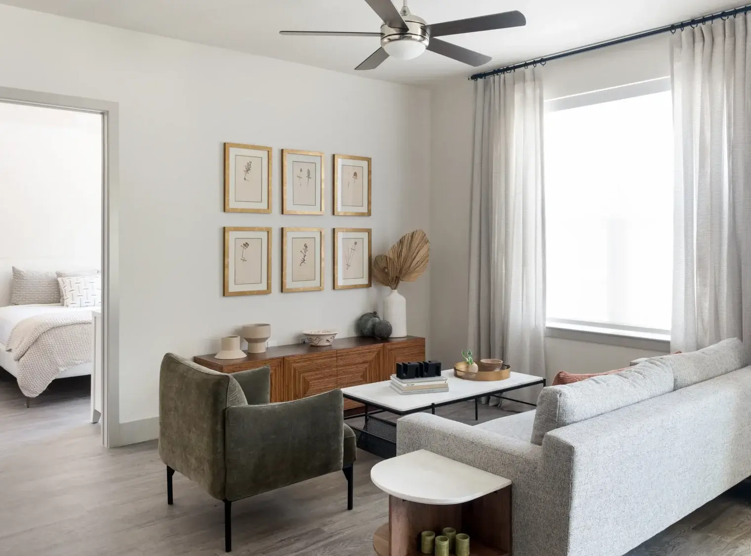 Contemporary apartment living room with ceiling fan and natural light at Six Pines near The Woodlands