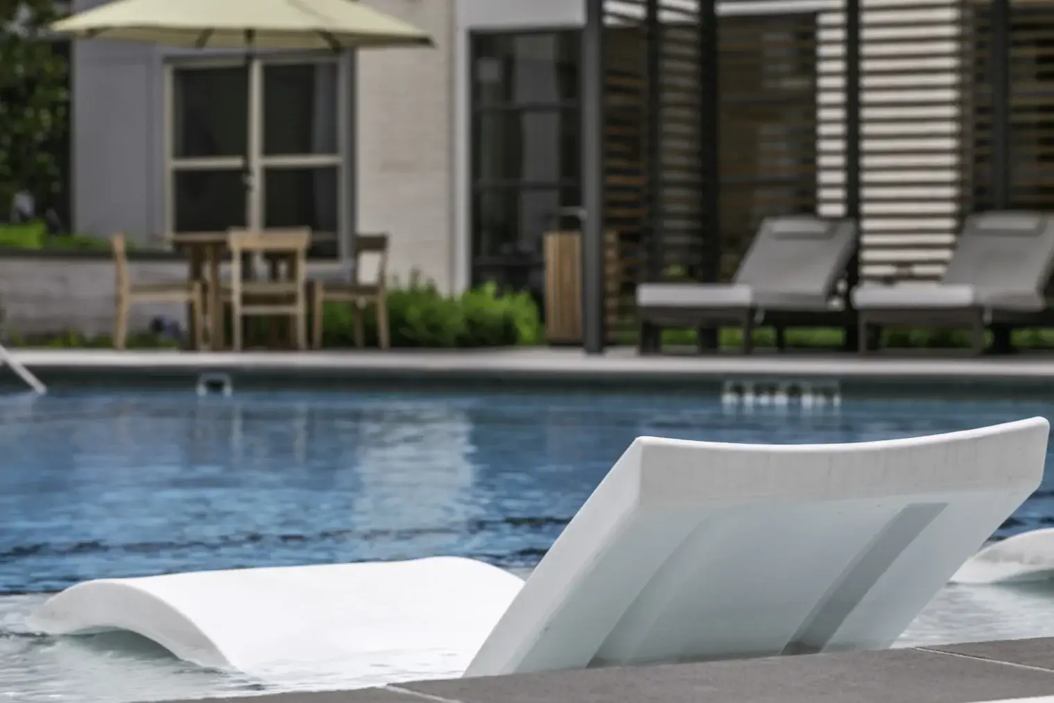 In-water pool lounge chairs at Six Pines apartment community in Shenandoah TX